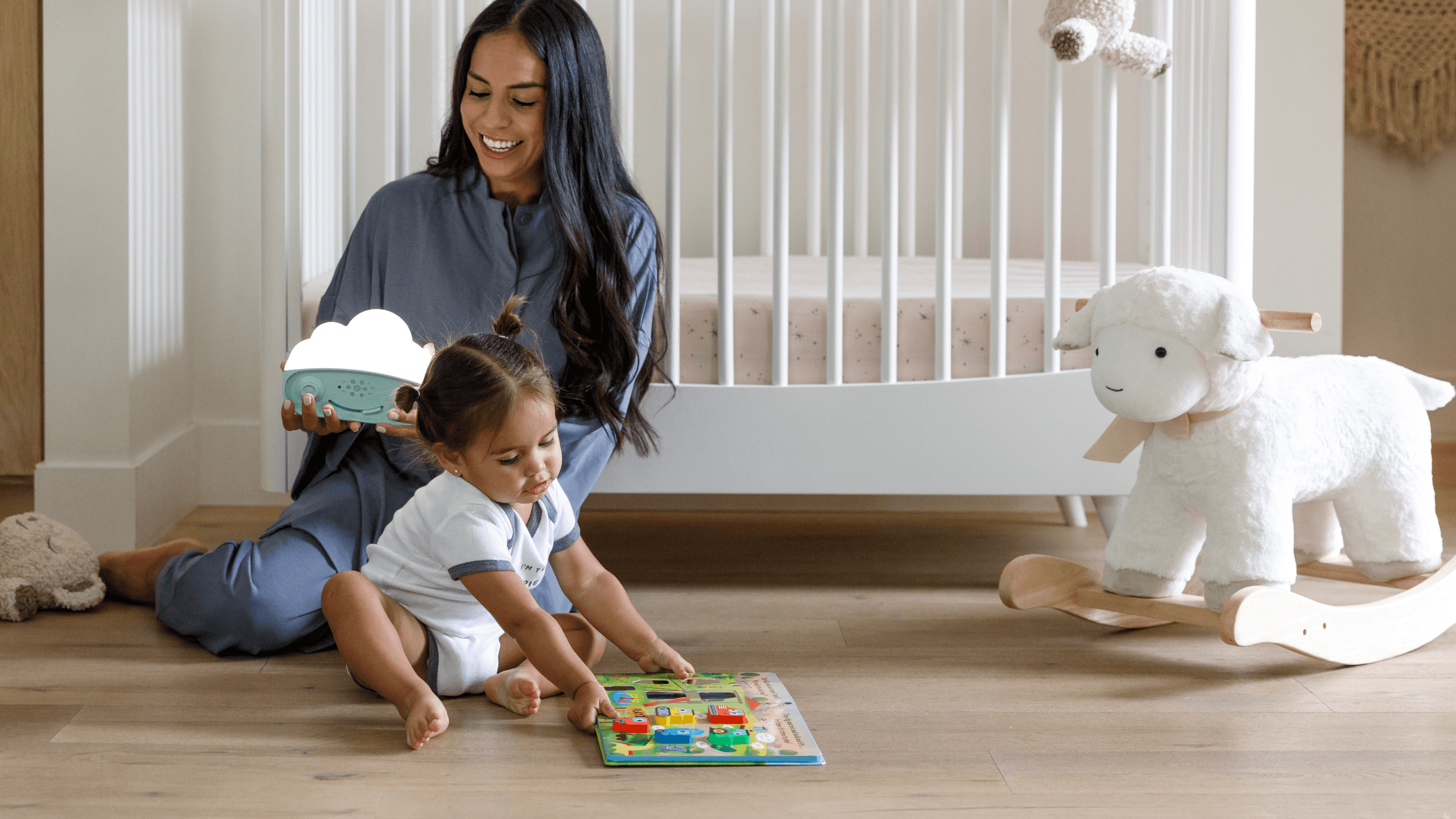 Baby playing with a book, while mom is holding a SNOObie