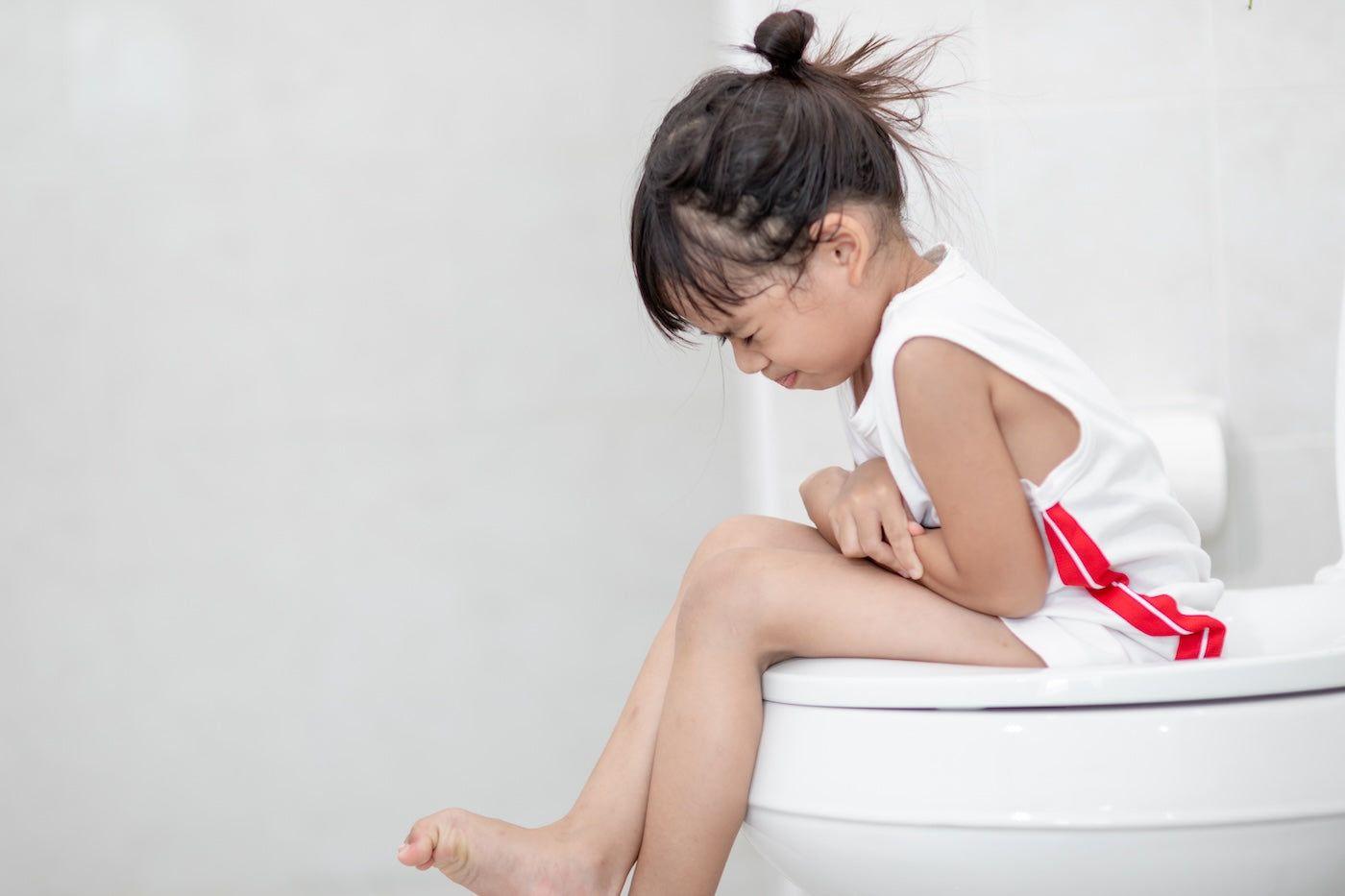 Toddler sits on the toilet refusing to poop