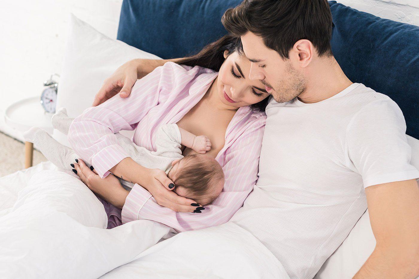 mom-breastfeeding-baby-with-dad-supporting-mom
