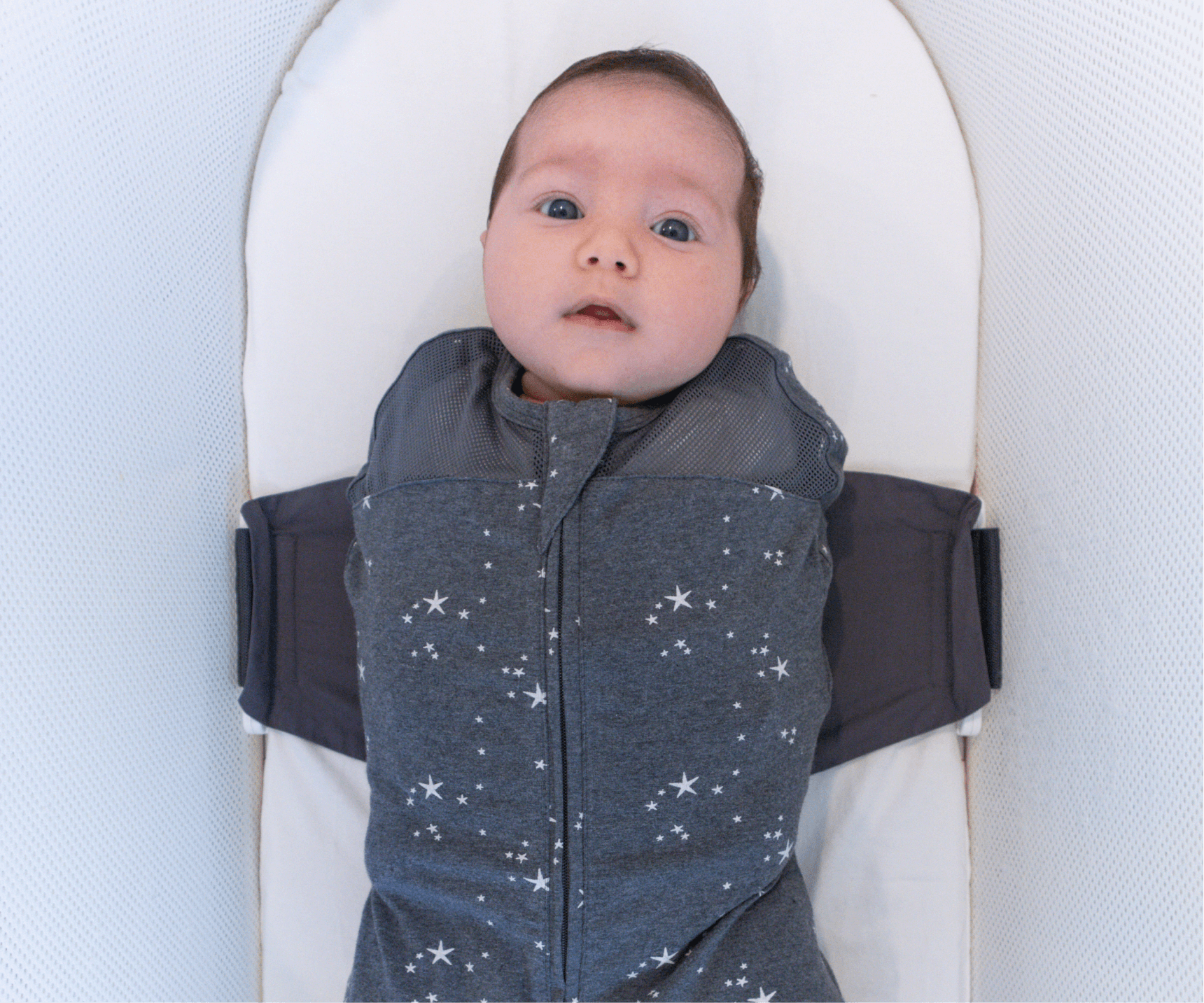 A baby in the SNOO Sleep Comforter Sack inside the SNOO bassinet