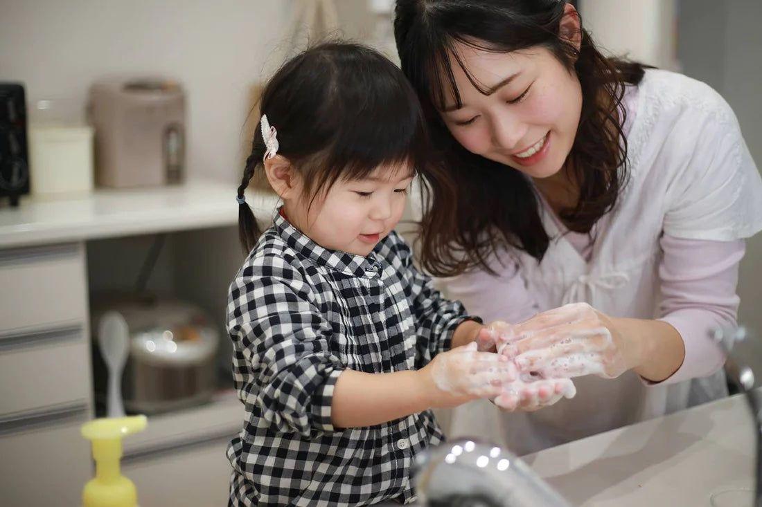 Mum and toddler daughter wash hands together