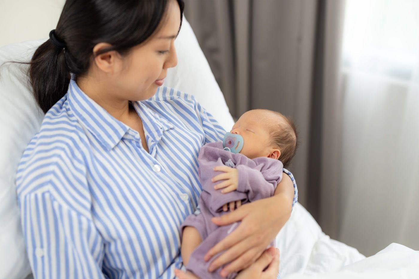New mum holds her newborn as she recovers from a c-section